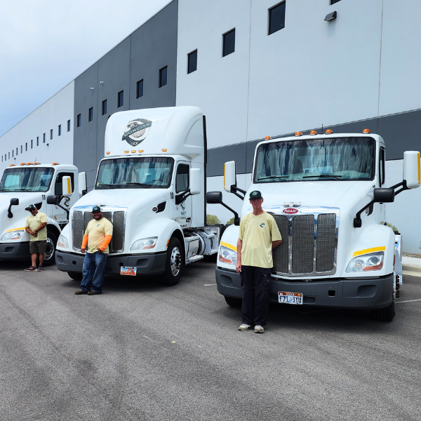Fleet of delivery trucks outside a logistics warehouse.