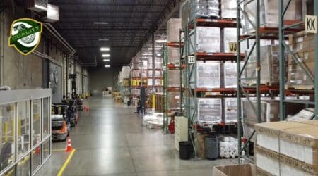 Large warehouse interior with forklifts moving inventory.