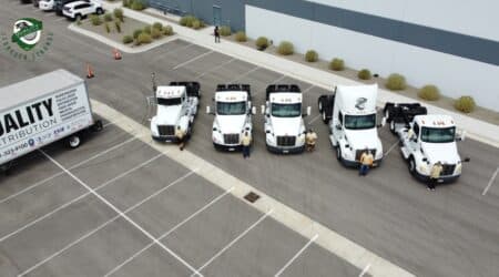 Aerial view of a large warehouse with loading docks and delivery trucks.